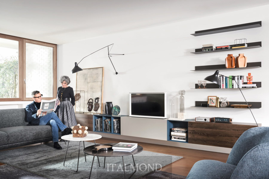 Гостиная с людьми, диваном и модульной стенкой с черными полками