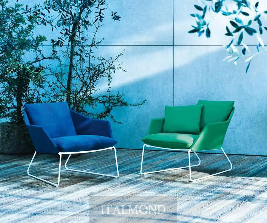 Синее и зеленое кресла с белыми ножками на террасе у стены