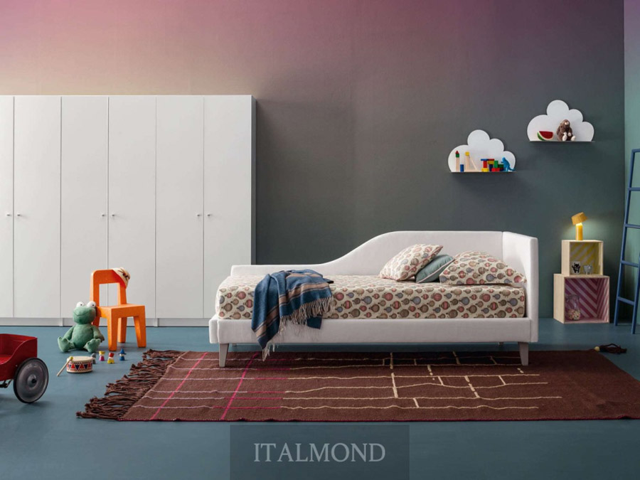 Детская комната с белой кроватью-диваном, игрушками и облаками на стене