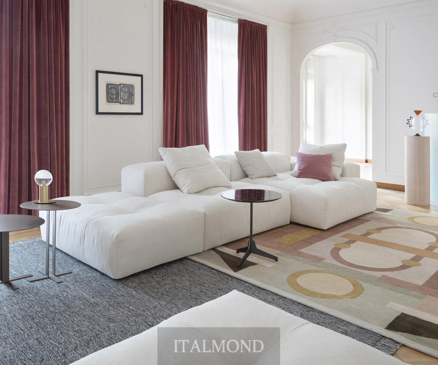 Белый модульный диван в гостиной с бордовыми шторами и ковром